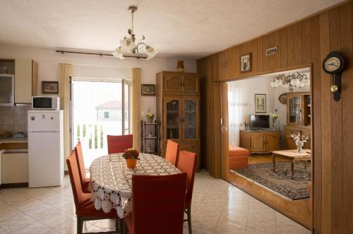 a kitchen and dining room with a table and chairs at Apartments by the sea Postira, Brac - 12291 in Postira