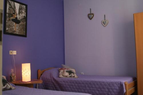 una camera da letto con pareti viola e 2 letti e una lampada di Apartments by the sea Ilovik, Losinj - 12275 a Ilovik