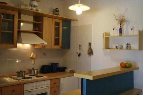 a kitchen with wooden cabinets and a stove top oven at Apartments by the sea Ilovik, Losinj - 12275 in Ilovik
