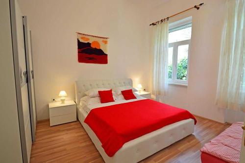 Un dormitorio con una cama con sábanas rojas y una ventana. en Apartments by the sea Rabac, Labin - 12308, en Rabac