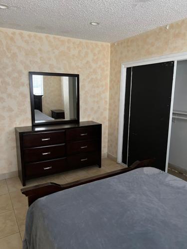 Un dormitorio con una cómoda con un espejo encima. en Lovely Berryman Ave Apartment, en Los Ángeles