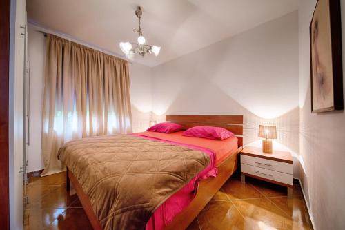 科米扎的住宿－Apartments with a parking space Komiza, Vis - 12325，卧室配有一张带粉红色枕头的大床