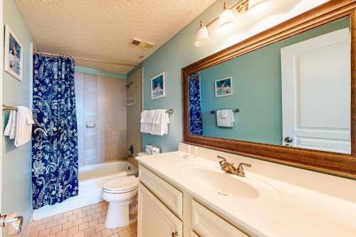 a bathroom with a sink and a toilet and a mirror at Silver Beach 205 in Orange Beach