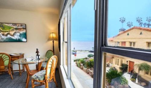 a living room with a table and a large window at Pantai Inn in San Diego
