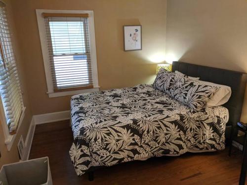 a bedroom with a bed with a black and white comforter at Ohio Ave 3 bed house Historic Downtown Loveland in Loveland