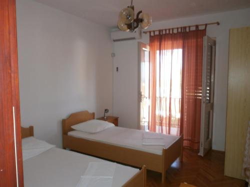 Habitación pequeña con 2 camas y ventana en Apartments by the sea Podgora, Makarska - 12326 en Podgora