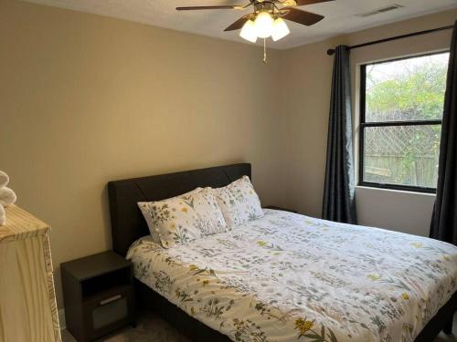 1 dormitorio con 1 cama, ventilador de techo y ventana en Park Ave 3 Bedroom House walk to Bike Trail, en Loveland