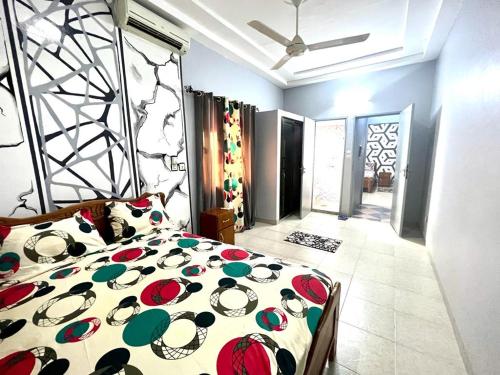 a bedroom with a bed with a colorful comforter at Deluxe résidence in Ouagadougou