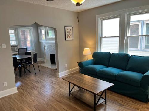 sala de estar con sofá azul y mesa en Warren 1 Bedroom Unit near Xavier Downtown en Bellevue
