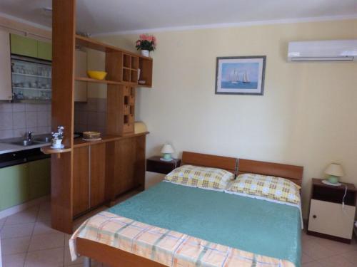 ein kleines Schlafzimmer mit einem Bett und einer Küche in der Unterkunft Studio Rabac 12368a in Rabac