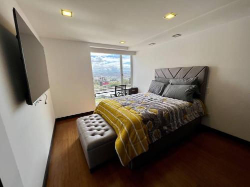 1 dormitorio con cama y ventana en Cama KING, piscina en SUITE de LUJO en zona privilegiada y céntrica, en Quito