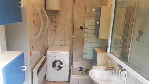 ein kleines Bad mit einer Waschmaschine und einem Waschbecken in der Unterkunft Apartments with WiFi Opatija - 12426 in Opatija
