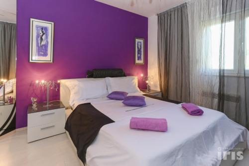 purpurowa sypialnia z dużym łóżkiem z fioletowymi poduszkami w obiekcie Apartments with a parking space Kastel Sucurac, Kastela - 12445 w mieście Kaštela