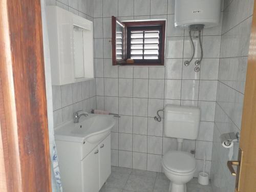 ein Bad mit einem WC und einem Waschbecken in der Unterkunft Apartments by the sea Metajna, Pag - 12443 in Zubovići