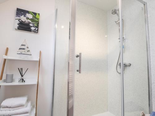 een badkamer met een douche en een glazen deur bij Firthview in Buckie