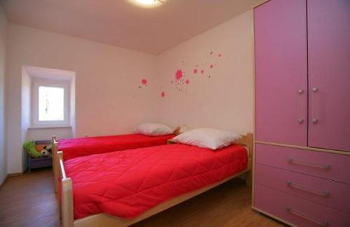 a bedroom with a red bed and a purple cabinet at Family friendly house with a parking space Presika, Labin - 12472 in Labin