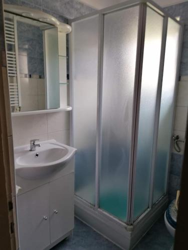 a bathroom with a sink and a shower with a mirror at Apartments and rooms by the sea Kampor, Rab - 12473 in Rab