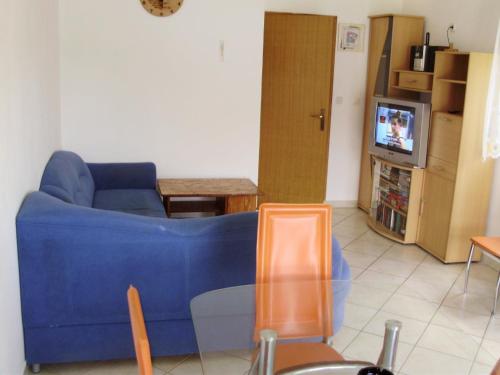 un salon avec un canapé bleu et une télévision dans l'établissement Apartments by the sea Kabli, Peljesac - 12475, à Janjina