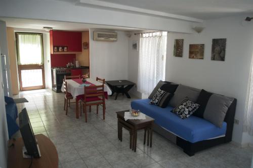 a living room with a blue couch and a table at Apartments by the sea Sibenik - 12454 in Šibenik