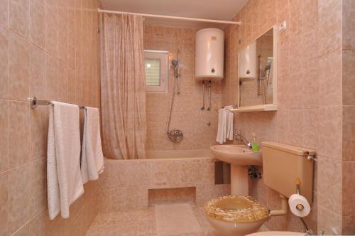 ein Badezimmer mit einem Waschbecken, einem WC und einer Badewanne in der Unterkunft Apartments by the sea Slatine, Ciovo - 12491 in Slatine