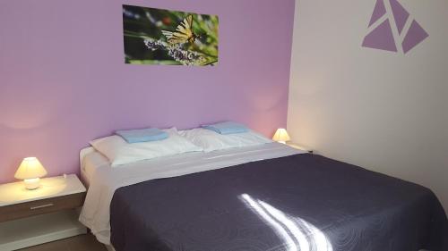 a bedroom with a large bed with two lamps at Apartments by the sea Zaglav, Dugi otok - 12504 in Sali