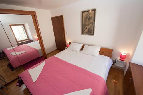 a bedroom with a pink and white bed and a mirror at Apartments with WiFi Split - 12523 in Split