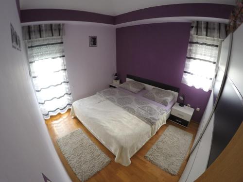 a small bedroom with a bed and two windows at Apartments with WiFi Omis - 12525 in Omiš