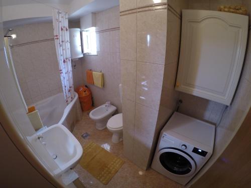 a bathroom with a toilet sink and a washing machine at Apartments with WiFi Omis - 12525 in Omiš
