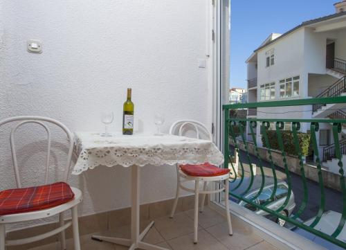einen Tisch mit einer Flasche Wein auf dem Balkon in der Unterkunft Apartments with a parking space Baska Voda, Makarska - 12543 in Baška Voda