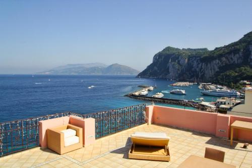 a balcony with a view of the water and a harbor at Capri Inn in Capri