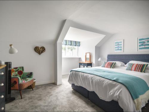 a bedroom with a large bed and a chair at 55 Queen Street in Seaton