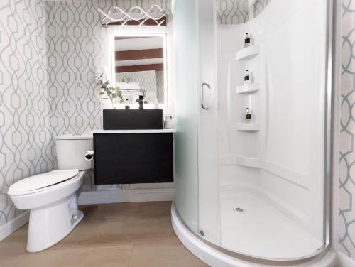 a bathroom with a toilet and a sink and a shower at Oceanside Villas in Sechelt