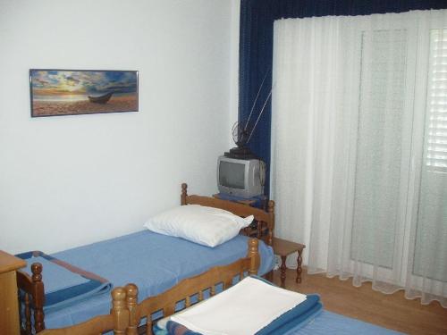 1 dormitorio con 1 cama y TV en una habitación en Apartments with a parking space Slano, Dubrovnik - 12576 en Slano