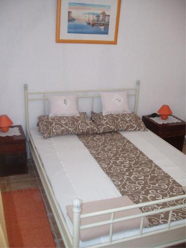 a bed in a bedroom with two nightstands and two lamps at Apartments with a parking space Slano, Dubrovnik - 12576 in Slano