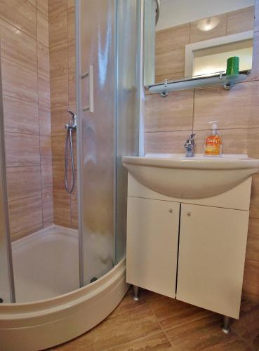 a bathroom with a sink and a shower at Apartments and rooms by the sea Rab - 12616 in Rab