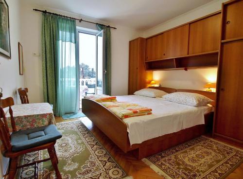 ラブにあるApartments and rooms by the sea Rab - 12616の大きなベッドと大きな窓のある寝室