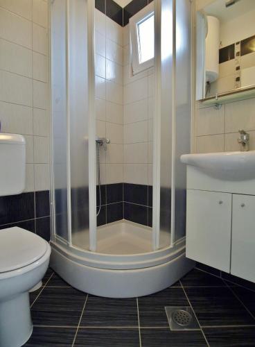 a bathroom with a shower and a toilet and a sink at Double Room Rab 12616b in Rab