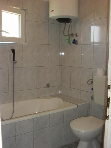a bathroom with a bath tub and a toilet at Rooms by the sea Cove Bristova - Hvar - 12140 in Bogomolje