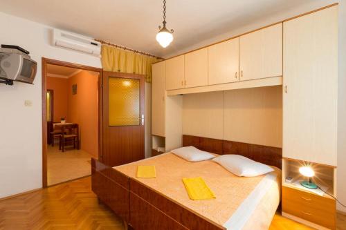 a bedroom with a bed with two yellow folders on it at Apartments by the sea Mali Losinj (Losinj) - 12634 in Veli Lošinj