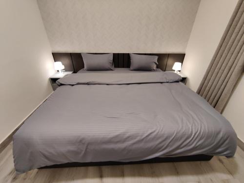 1 dormitorio con 1 cama grande y 2 almohadas en 44m luxury room near downtown and all services en Amán