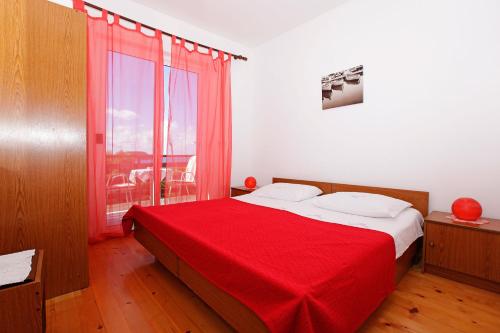 a bedroom with a bed with a red blanket at Apartments by the sea Prizba, Korcula - 12648 in Prizba