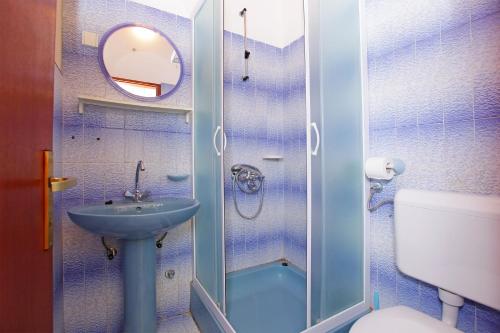a bathroom with a shower with a sink and a toilet at Apartments by the sea Prizba, Korcula - 12648 in Prizba