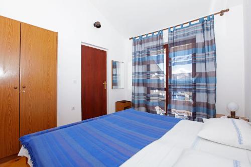 a bedroom with a blue bed and a window at Studio Prizba 12648d in Prizba