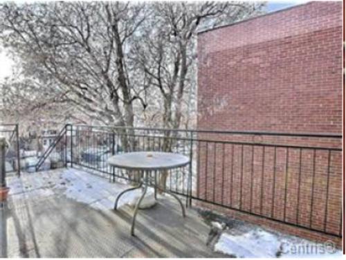 a balcony with a table and a brick wall at BIG 3BR appartment at Olympic Stadium at PIE-IX Metro station in Montréal