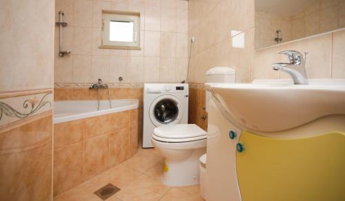 y baño con aseo, lavabo y lavadora. en Apartments with a parking space Ostrvica, Omis - 12674, en Gata