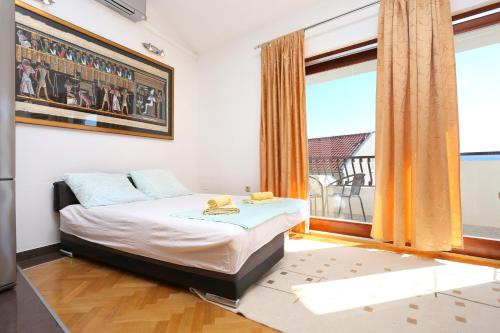 ein Schlafzimmer mit einem Bett und einem großen Fenster in der Unterkunft Apartments by the sea Duce, Omis - 12687 in Dugi Rat