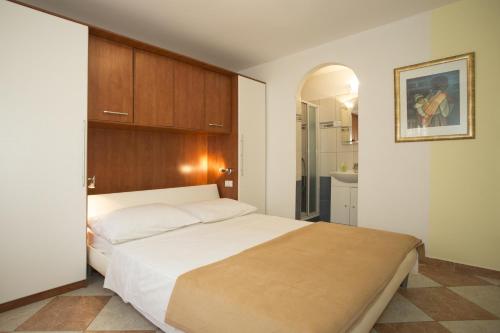 1 Schlafzimmer mit einem großen Bett und einem Badezimmer in der Unterkunft Apartment Mavarstica 12696a in Trogir