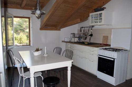 een keuken met een tafel en een witte kookplaat bij Apartments by the sea Cove Salbunara - Bisevo, Vis - 12700 in Komiža