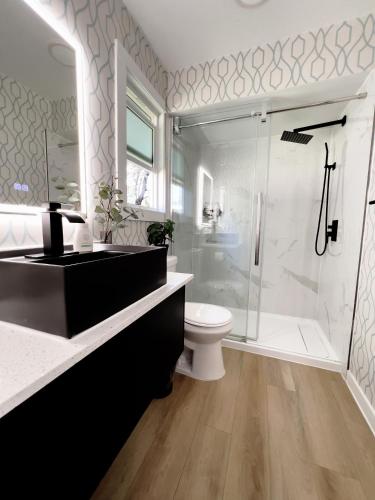 a bathroom with a shower and a toilet and a sink at Oceanside Villas in Sechelt