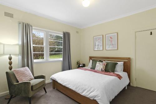 1 dormitorio con 1 cama, 1 silla y 1 ventana en Katoomba Getaway en Katoomba
